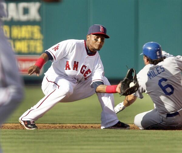 Dodgers' baserunner Aaron Miles, right, slides into second base past the tag of Angels shortstop Erick Aybar during the second inning of the Angels' 3-1 victory Sunday.