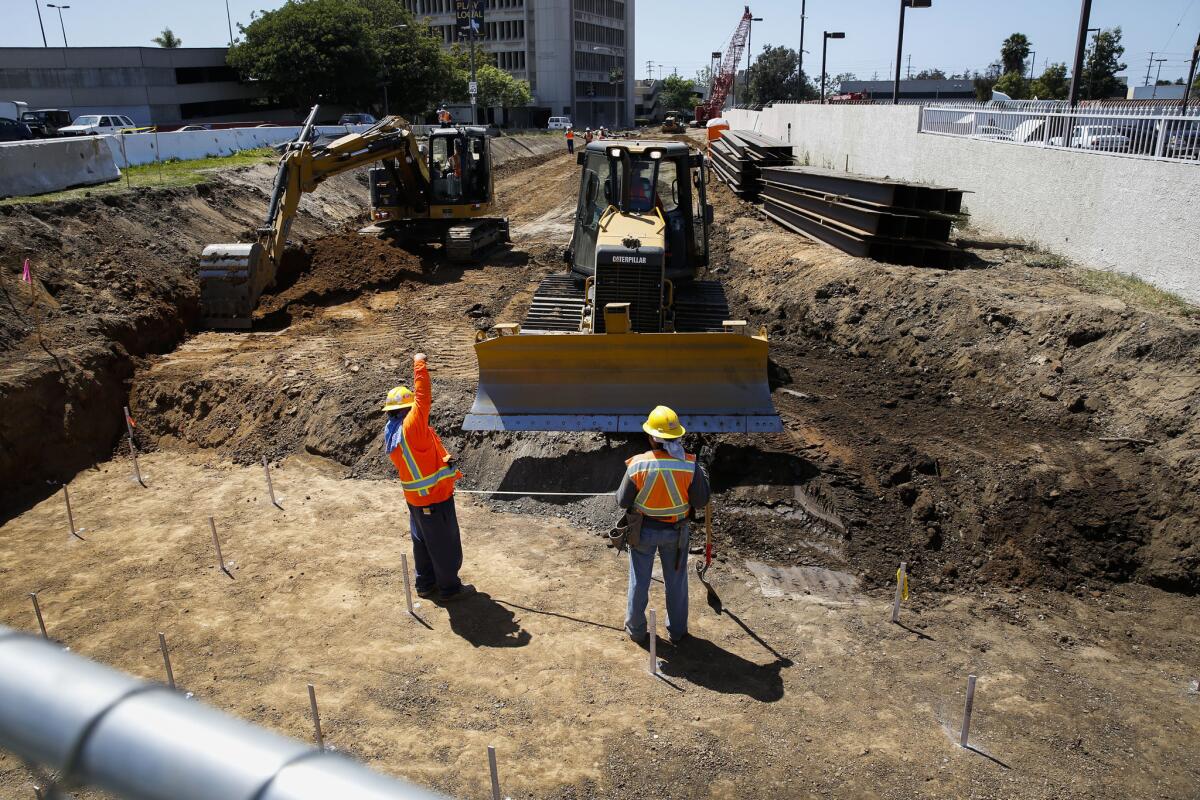 Workers prepare to install pilings for a bridge on the Metro Crenshaw Line at the intersection of La Brea and Florence avenues in April. Excavation for two one-mile tunnels on the line will begin next year.