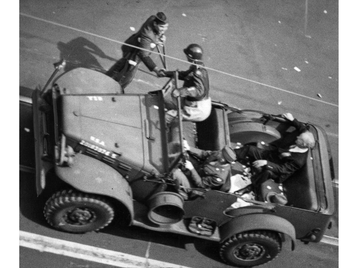June 9, 1945: Gen. George S. Patton Jr. stops his jeep during the parade to shake hands with soldier who had served in his command during World War II. The wounded veteran disappeared back into crowd before he could be identified.