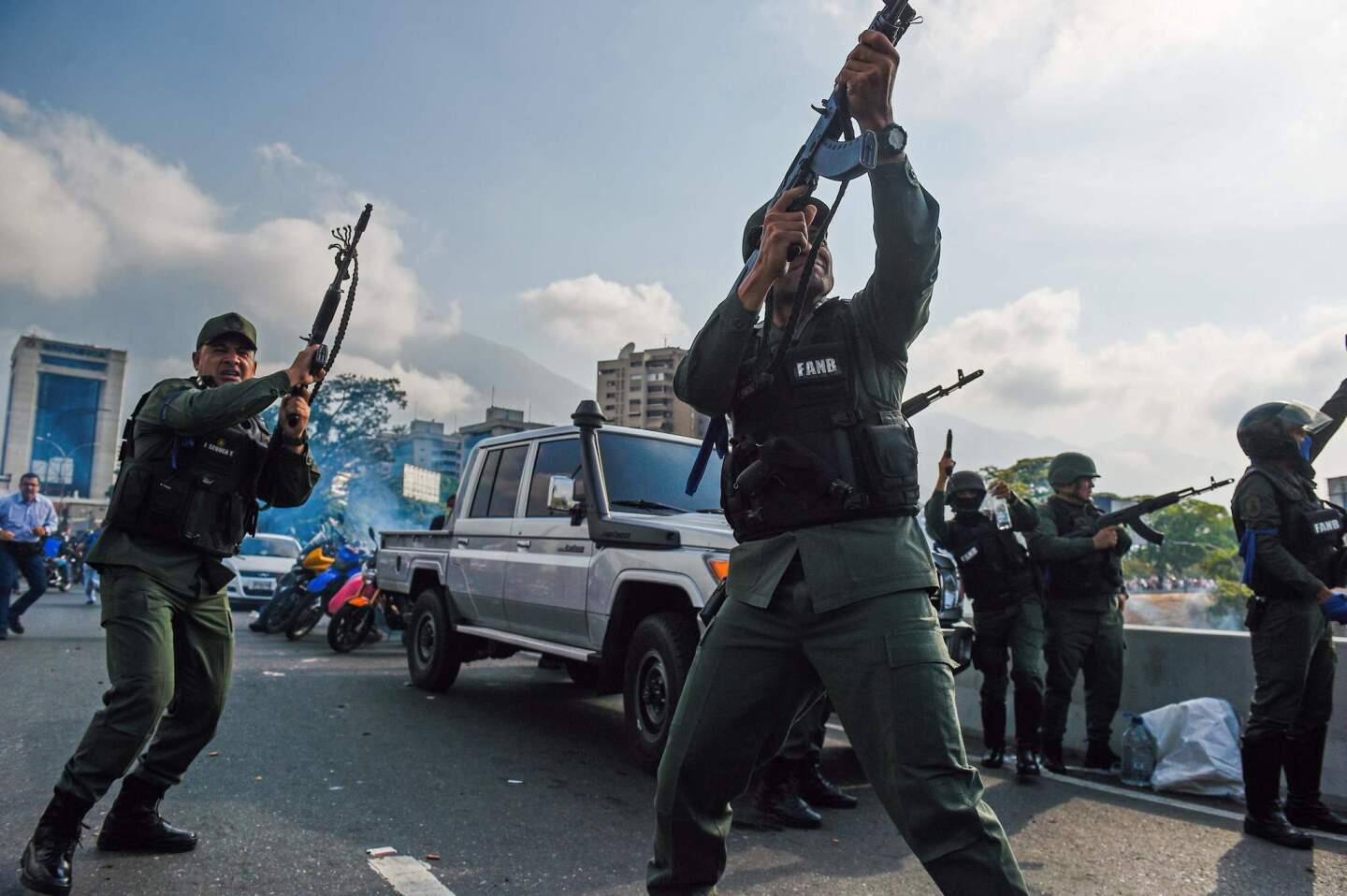 Members of the Bolivarian National Guard who joined Venezuelan opposition leader and self-proclaimed acting president Juan Guaido fire into the air to repel forces loyal to President Nicolas Maduro who arrived to disperse a demonstration near a military base in Caracas.