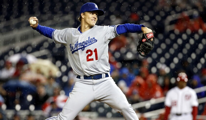 Dodgers starting pitcher Zack Greinke delivers a pitch against the Natinoals as rain falls in the fourth inning on Monday night in Washington. Soon afterward, the rain became heavy and the game was halted for more than three hours.