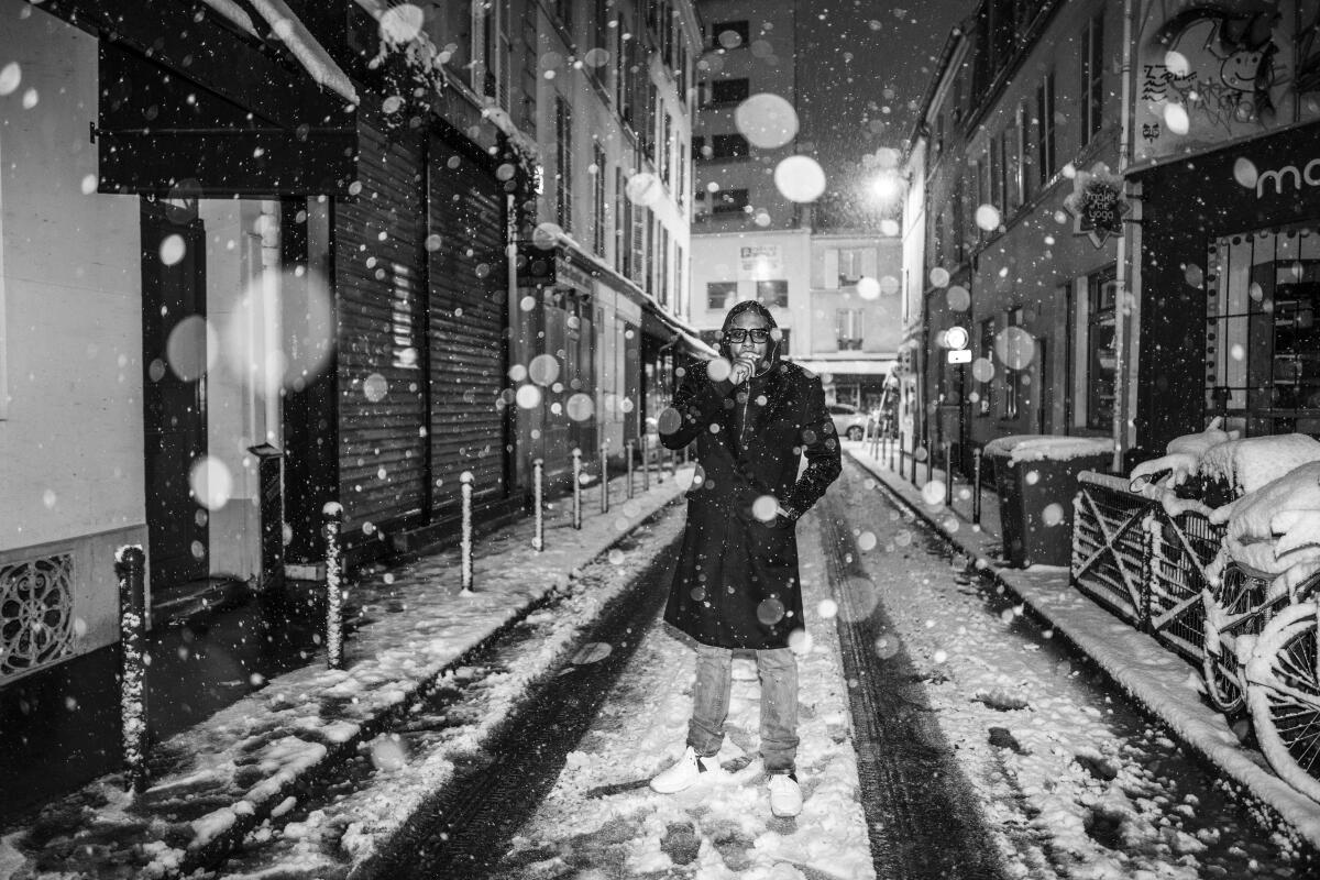 Dave Chappelle smoking a cigarette in the snow from "Paris Blues" exhibition at Leica Gallery Los Angeles, 2024