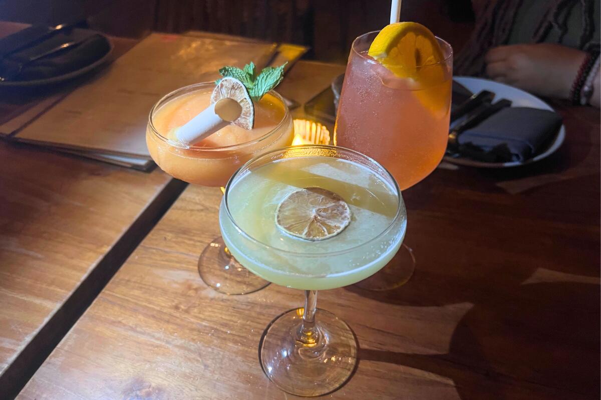 Three colorful cocktails on a wooden table