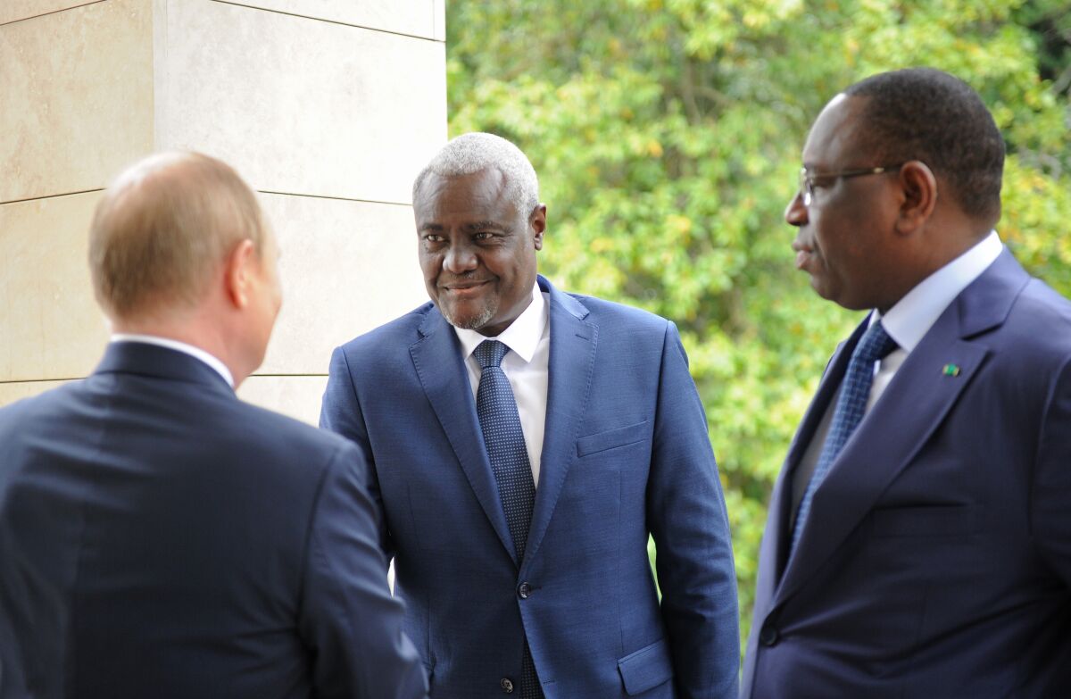 Russian President Vladimir Putin, left back to a camera, speaks greets African Union Commission Chairperson Moussa Faki Mahamat, center, and Senegalese President and the chairman of the African Union Macky Sall during their meeting in the Bocharov Ruchei residence in the Black Sea resort of Sochi, Russia, Friday, June 3, 2022. (Mikhail Klimentyev, Sputnik, Kremlin Pool Photo via AP)