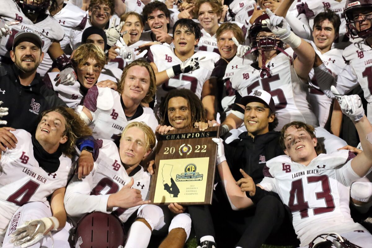The Laguna Beach football team with the 2022 CIF Southern Section Division 9 championship plaque.