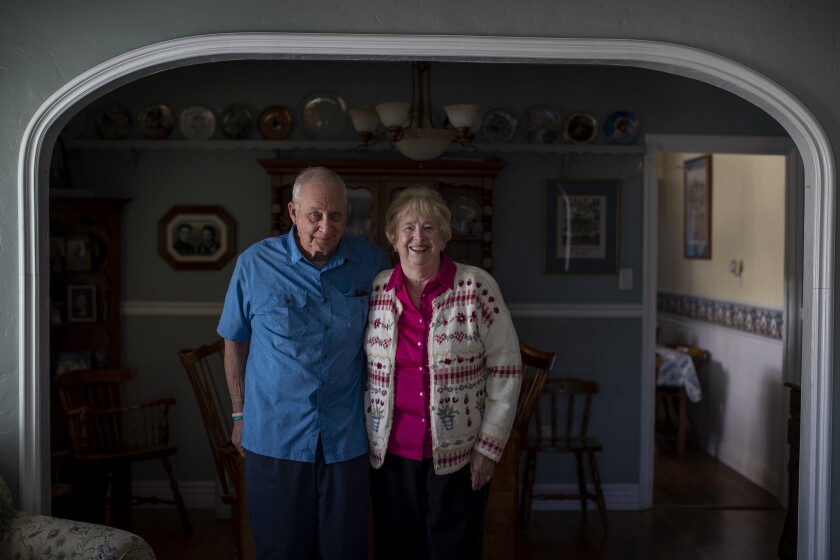 A couple poses for a photo inside their home.