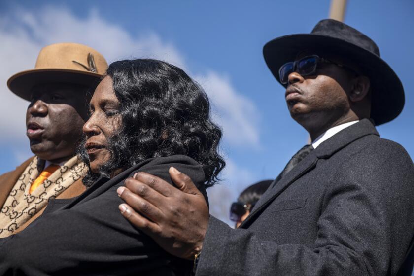 RowVaughn Wells, center, the mother of Tyre Nichols, stands with attorneys Ben Crump, left, and Kareem Ali as she speaks during a press conference after an indictment hearing for five former Memphis police officers charged in the death of her son at the Shelby County Criminal Justice Center Friday, Feb. 17, 2023, in Memphis, Tenn. (AP Photo/Brandon Dill)