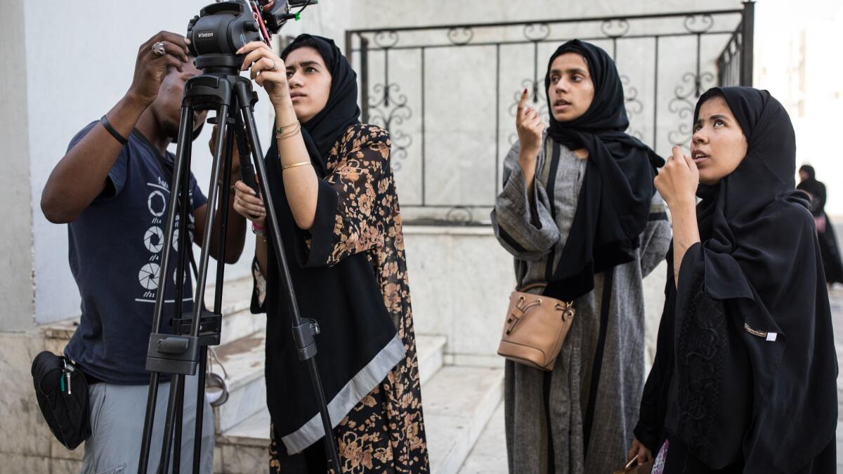 Assistant director Jowaher Alamri, right, consults with other crew members during filming for the short "Tayseer" in Jidda, Saudi Arabia.