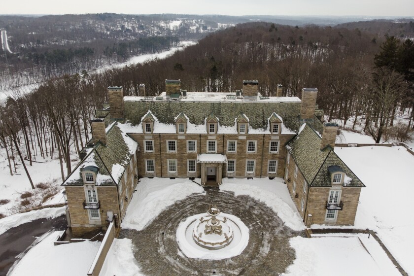 A mansion and its surrounding property are covered in snow.
