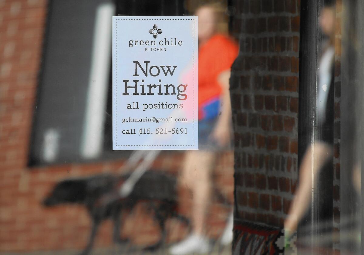 A "now hiring" sign is posted in the window of a business in San Rafael, Calif. State employers added 41,500 nonfarm payroll jobs in October.