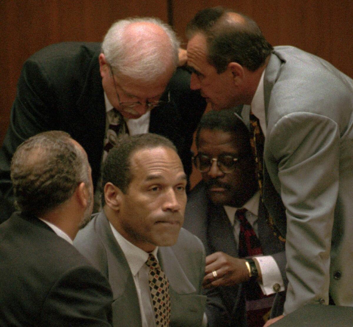 O.J. Simpson is surrounded by his attorneys — clockwise from left, Ken Spaulding (back toward camera), Gerald Uelmen, Robert Shapiro and Johnnie Cochran Jr. — in court in Los Angeles on Aug. 29, 1995.