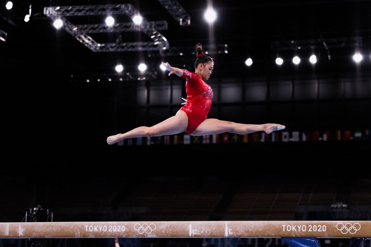 Sunisa Lee leaps high above the balance beam at the Tokyo Olympics