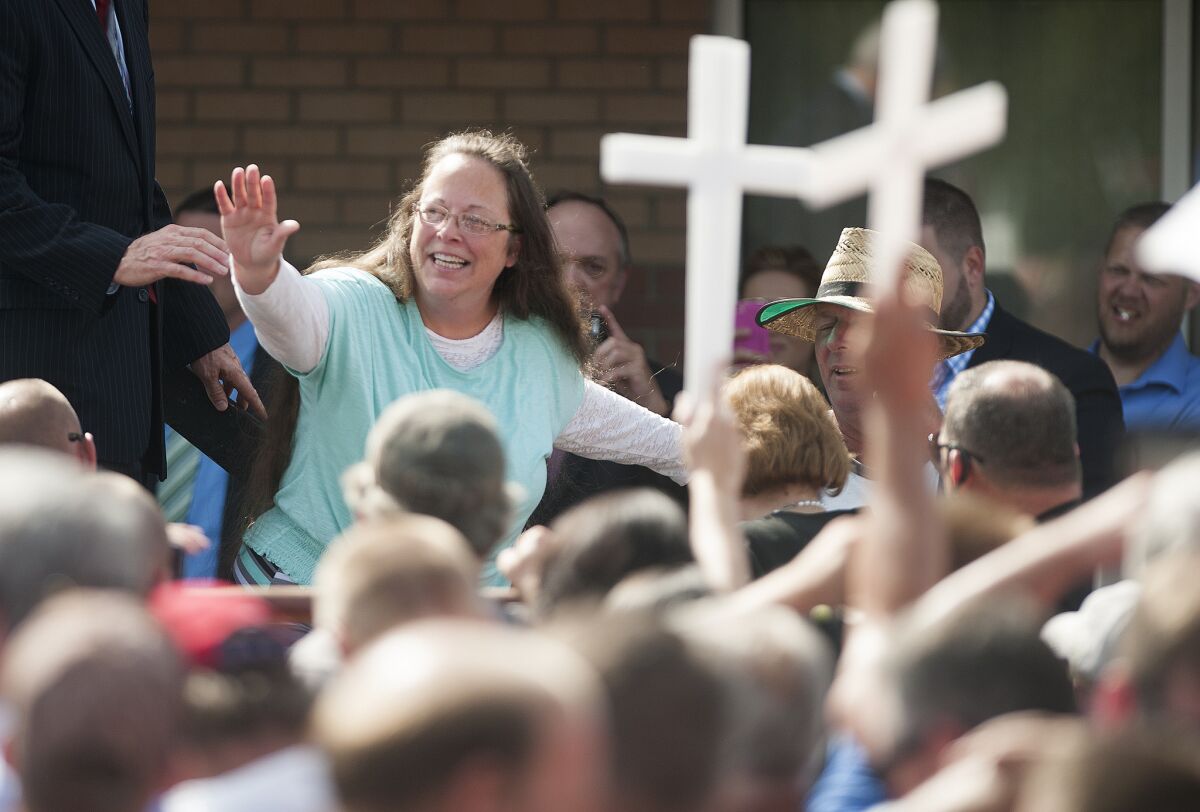 Kim Davis waves to supporters holding crosses in front of a Grayson, Ky., detention center on Sept. 8. 