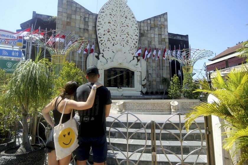 Australian tourists pay their respect to Bali bomb victims at the Bali Bombing Memorial in Kuta, Bali, Indonesia on Friday, Aug. 19, 2022. Australia's leader said Friday that it's upsetting Indonesia has further reduced the prison sentence of the bombmaker in the Bali terror attack that killed 202 people, which could free him within days if he's granted parole. (AP Photo/Firdia Lisnawati)