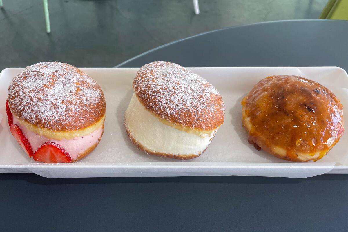 Three doughnuts on a white rectangular tray