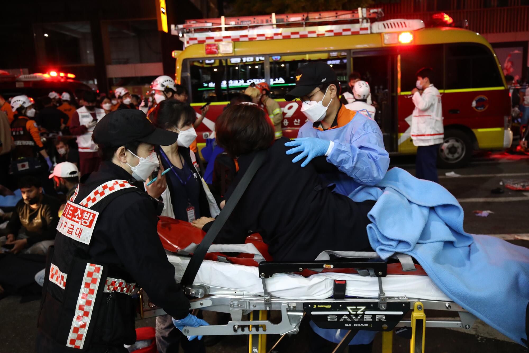 Emergency workers move a person on a gurney 