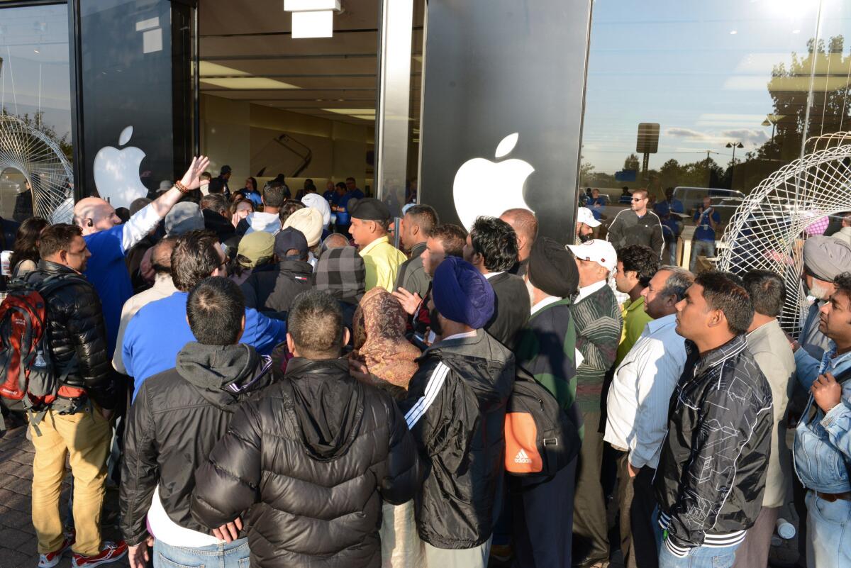 Apple Store employees in Woodcliff Lake, N.J., try and control the crowd as the store opens Friday, the first day of sales for the iPhone 6 and the iPhone 6 Plus.