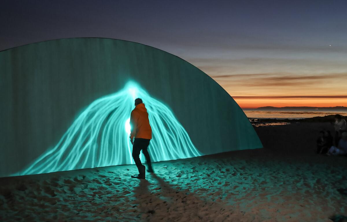 Cristopher Cichocki draws lines with a flashlight on his luminescent sculpture.