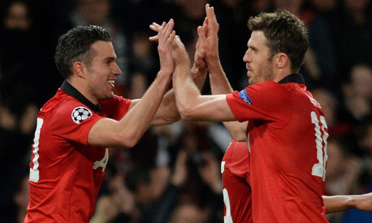 Manchester United's Robin van Persie, left, celebrates with teammate Michael Carrick after scoring against Olympiakos in a UEFA Champions League match on March 18. Stateside ownership of the Manchester United has done little to tarnish its legacy of success on the field.