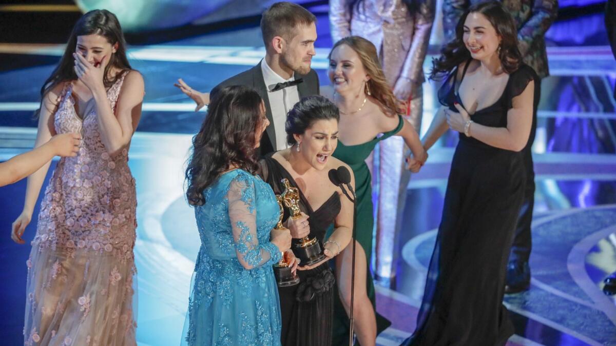 Melissa Berton (center, left) and Rayka Zehtabchi (center, right) accept the Short Film (Live Action) award for "Period. End Of Sentence."