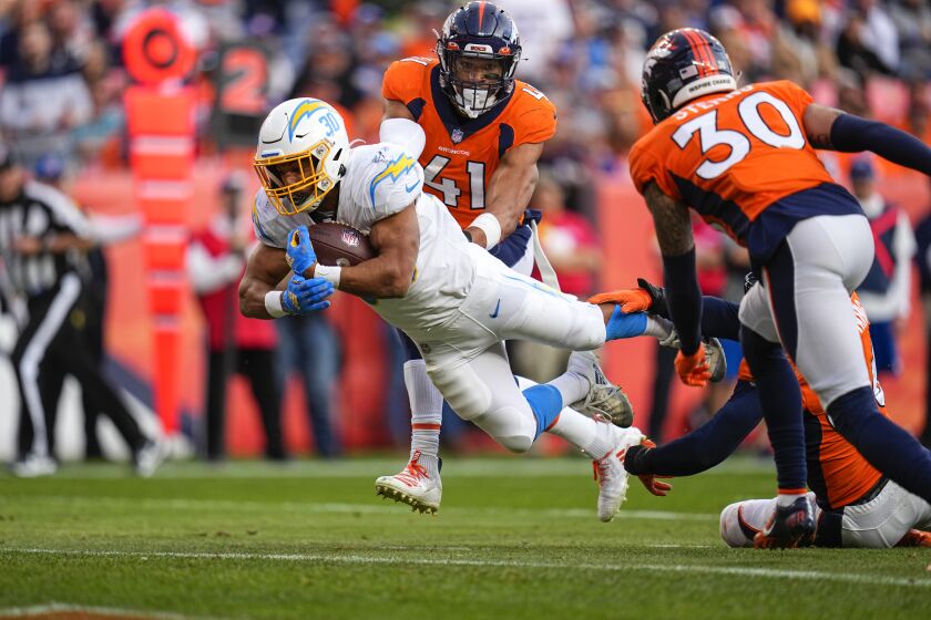 Los Angeles Chargers running back Austin Ekeler (30) runs for a touchdown against the Denver Broncos during an NFL football game Sunday, Nov. 28, 2021, in Denver. (AP Photo/Jack Dempsey)