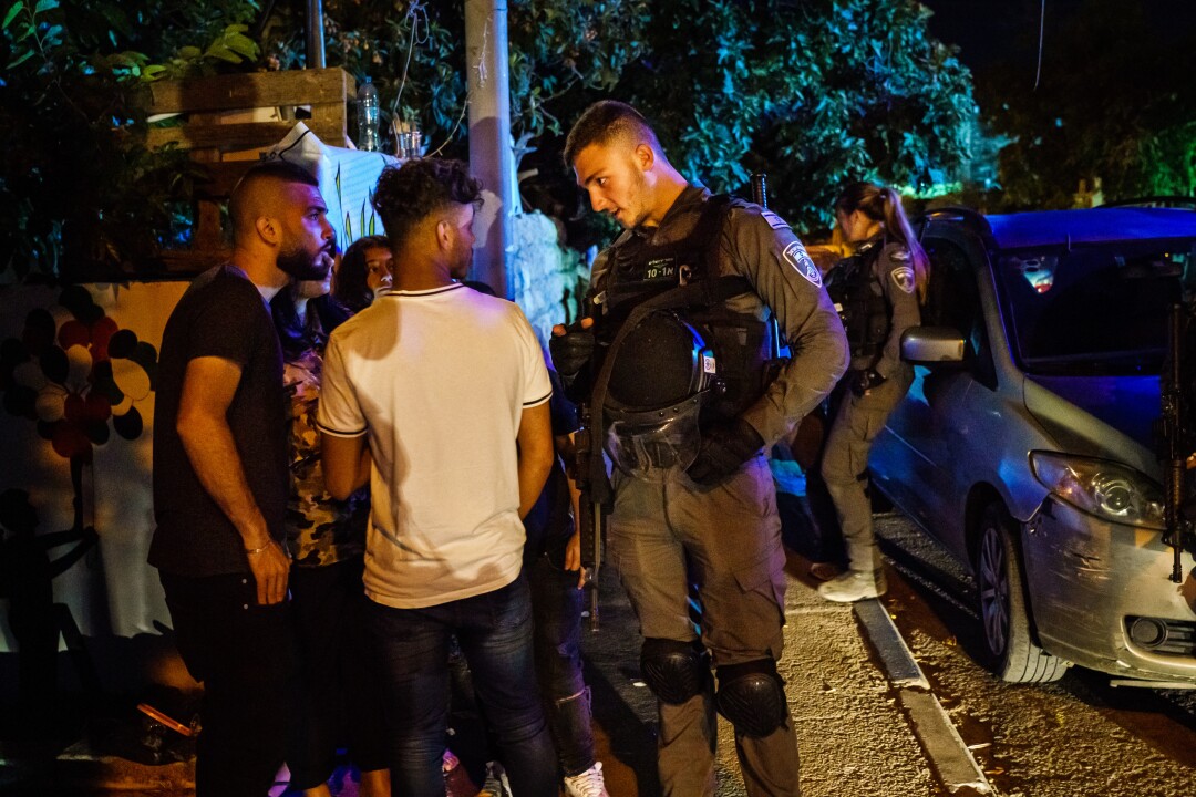 Ein israelischer Sicherheitsbeamter befragt junge Einwohner auf den Straßen des Viertels Sheikh Jarrah in Ostjerusalem
