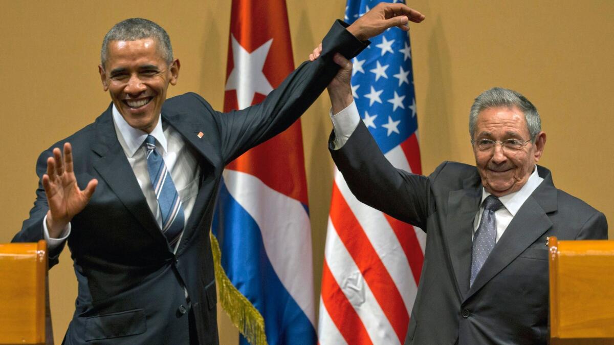 Cuban President Raul Castro lifts up the arm of President Barack Obama at the conclusion of their joint news conference at the Palace of the Revolution, in Havana, Cuba on March 21.