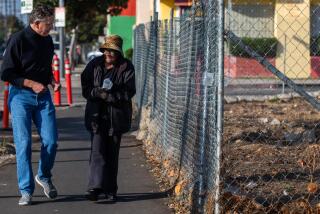 Los Angeles, CA - Richard Parks, left, President of the South L.A. nonprofit Redeemer Community Partnership, walks with neighbor QC Kelker, right, next to a field on Jefferson Blvd. Thursday, Dec. 7, 2023, in Los Angeles, CA. After a years-long neighborhood battle against an oil drilling site in South Los Angeles, a local nonprofit has purchased the now-demolished facility and plans to transform it into a park, community center, and affordable housing. (Francine Orr / Los Angeles Times)