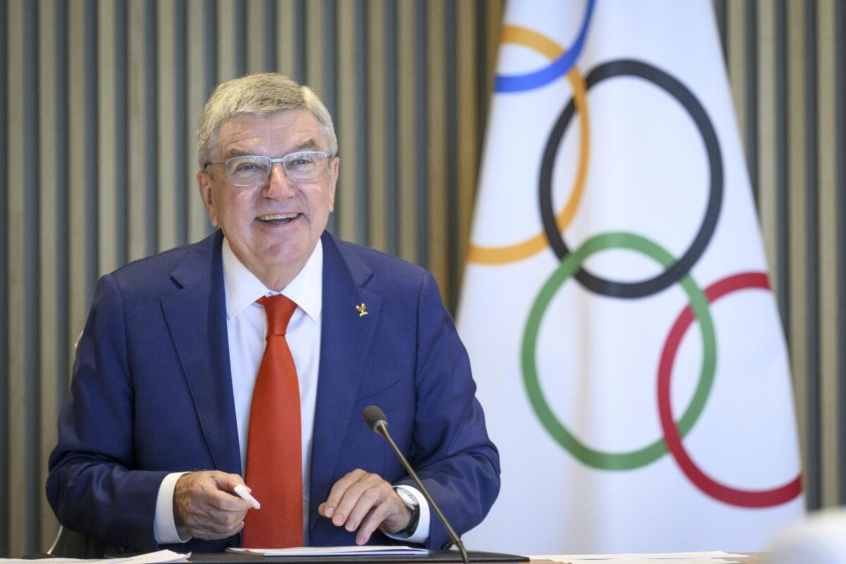 International Olympic Committee President Thomas Bach with Olympic flag behind him