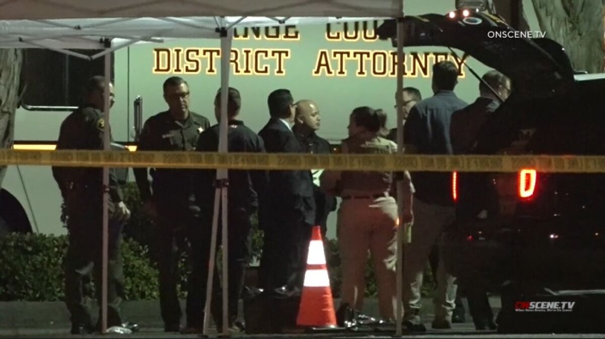 Law enforcement officials gather at the scene of a shooting in Lake Forest early Wednesday.