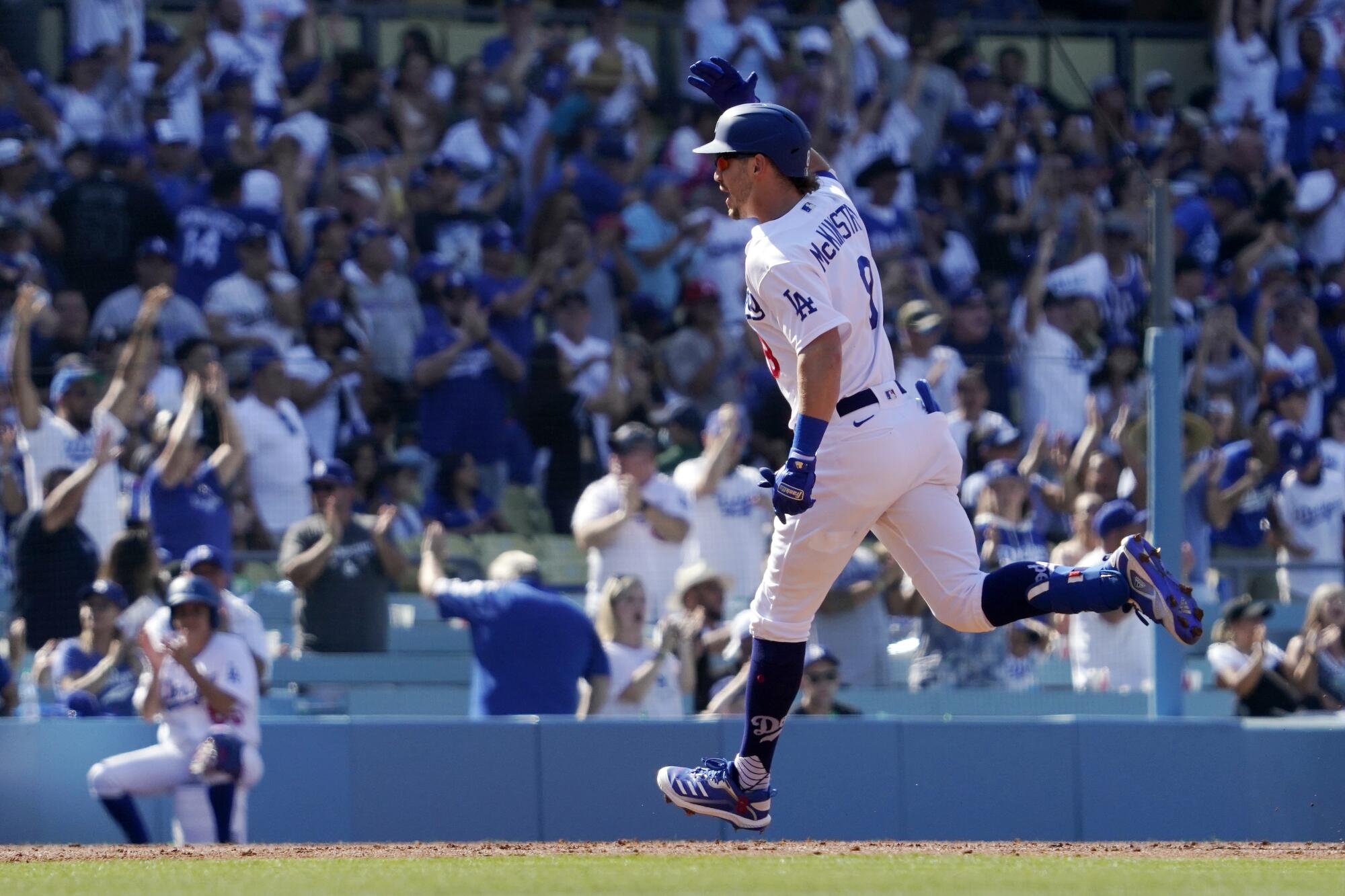 Los Angeles Dodgers' Zach McKinstry gestures as he heads to third after hitting a grand slam.