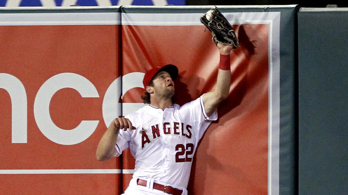Angels left fielder Kirk Nieuwenhuis hits the wall as he catches a fly ball hit by Detroit's J.D. Martinez in the seventh inning Friday night in Anaheim.