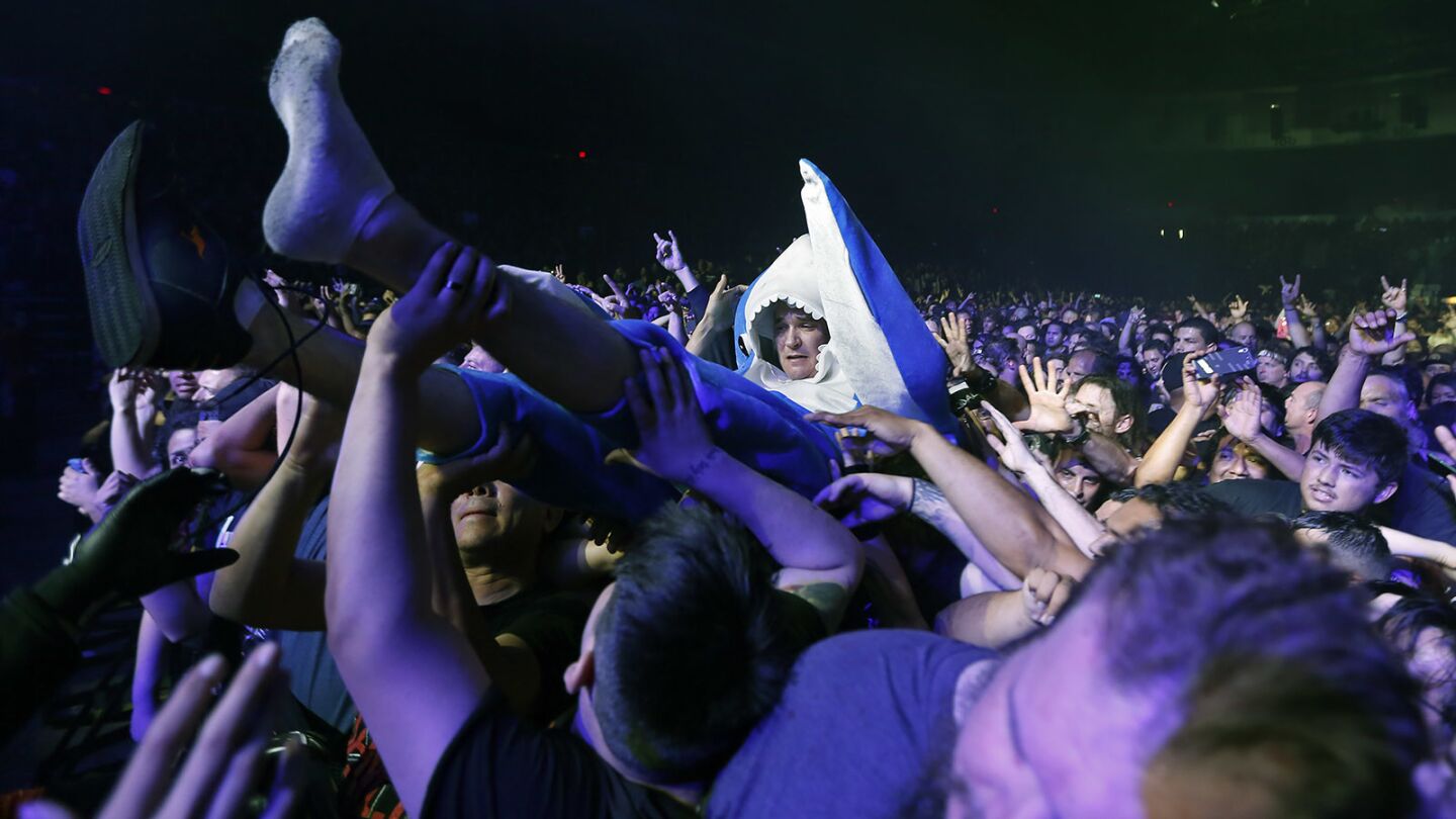 A fan in a shark outfit crowd surfs as the band Slayer plays during the opening night of their farewell tour in San Diego on May 10, 2018. (Photo by K.C. Alfred/ San Diego Union -Tribune)