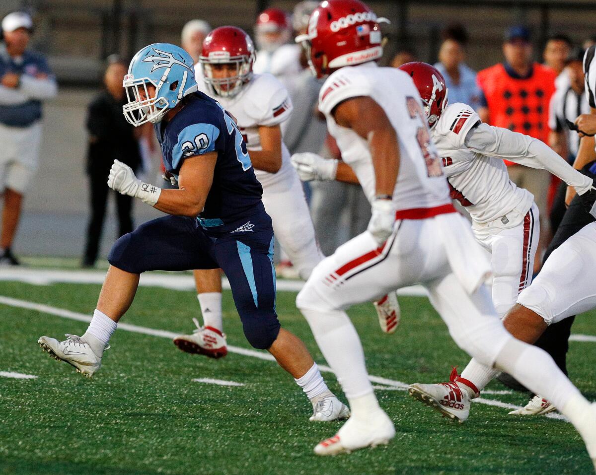 Corona del Mar's Jason Vicencio breaks through the Lakewood defense for a first down in a nonleague game at Newport Harbor High on Friday.