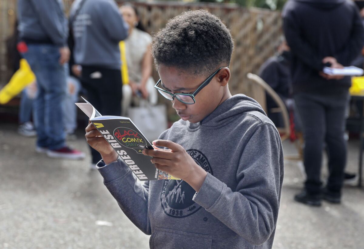 Aiden Richardson, 10, looks over a comic book at the San Diego Black Comix Day 2023.