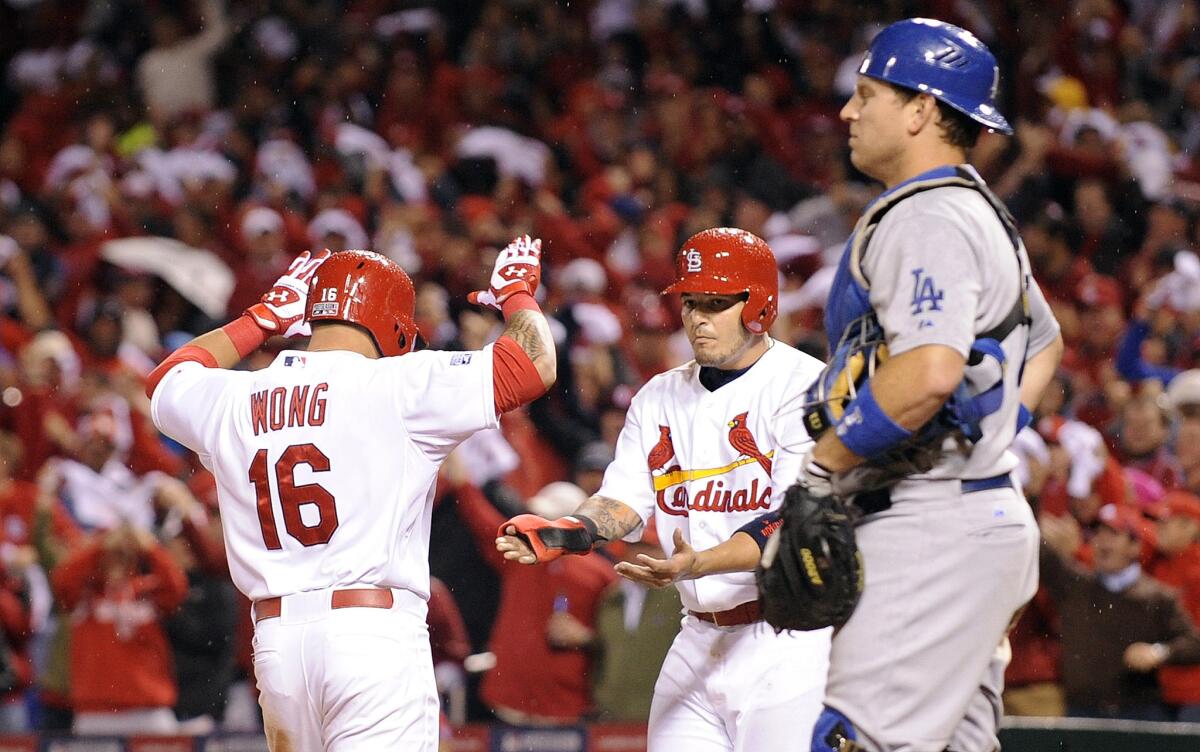 Cardinals second baseman Kolten Wong (16) is congratulated by teammate Yadier Molina after hitting a two-run home run against the Dodgers in Game 3 of the NLDS last season.