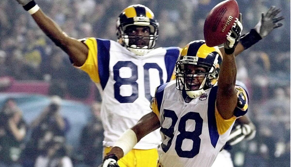 St. Louis Rams wide receiver Torry Holt and teammate Isaac Bruce celebrate Holt's touchdown catch during second half of Super Bowl XXXIV at the Georgia Dome in Atlanta on Jan. 30, 2000.
