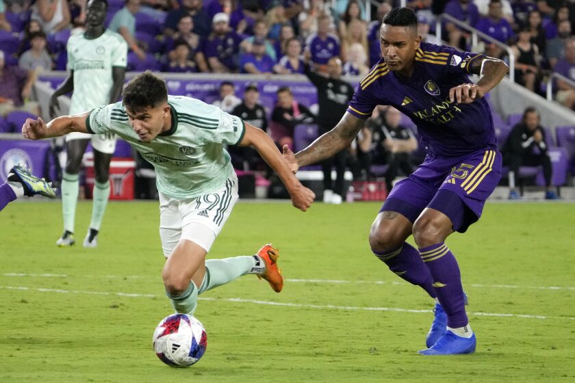 Atlanta United forward Miguel Berry (19) looks to shoot as he gets past Orlando City defender Antonio Carlos, right, during the second half of an MLS soccer match, Saturday, May 27, 2023, in Orlando, Fla. (AP Photo/John Raoux)
