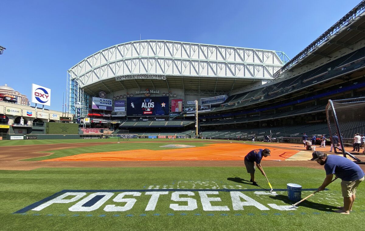 Minute Maid Park grounds crew paint the baseball postseason logo on the field before a Houston Astros team workout on Tuesday, Oct. 5, 2021, in Houston. The Astros are preparing for the American League Division Series against the Chicago White Sox. (Kevin M. Cox/The Galveston County Daily News via AP)