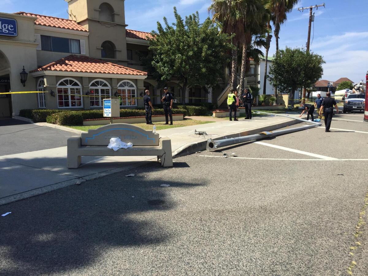 A bus bench and a light pole were hit by an SUV that also struck and killed a pedestrian in front of the Travelodge motel on Newport Boulevard in Costa Mesa.