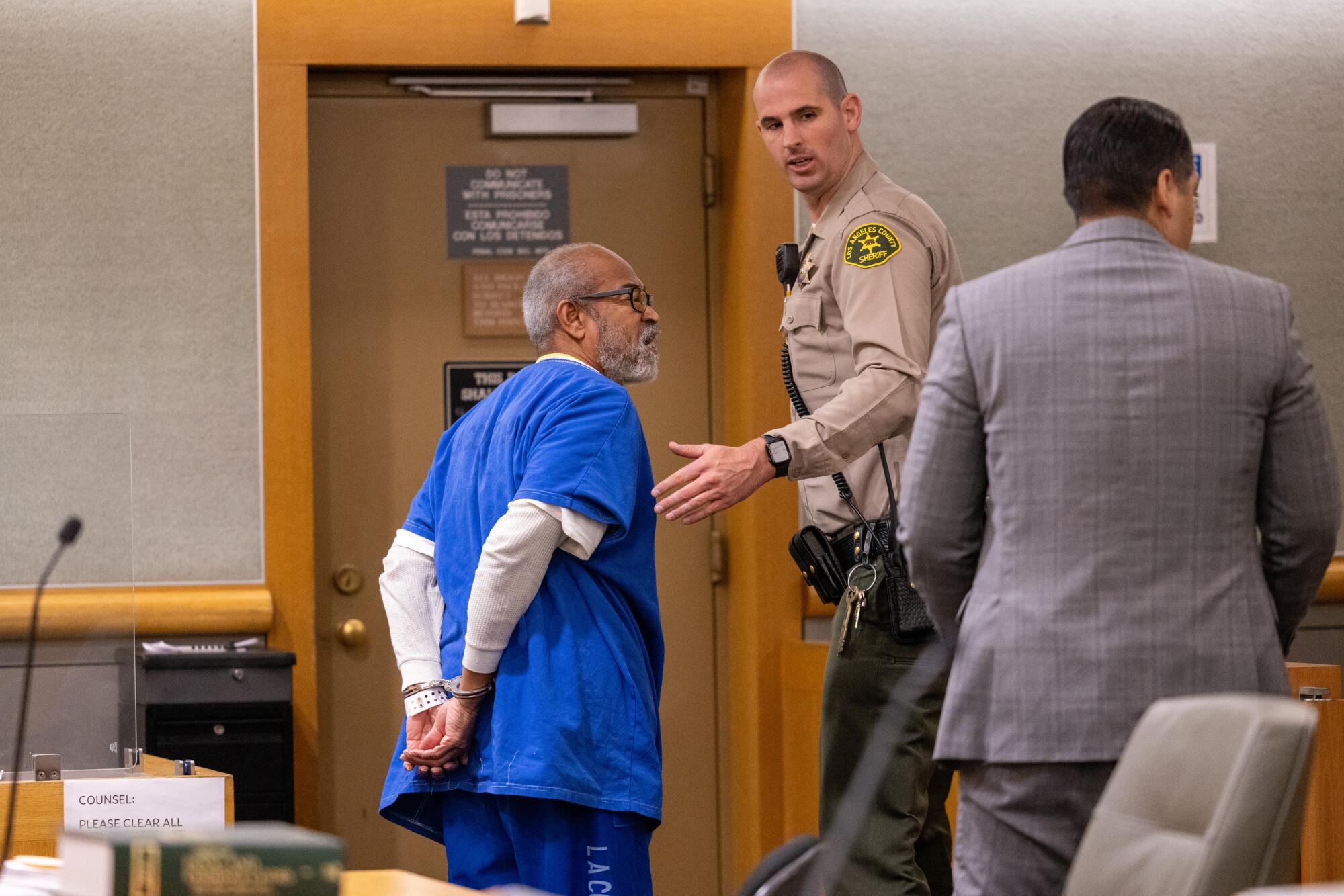 A handcuffed Bruce Bell is led out of court.