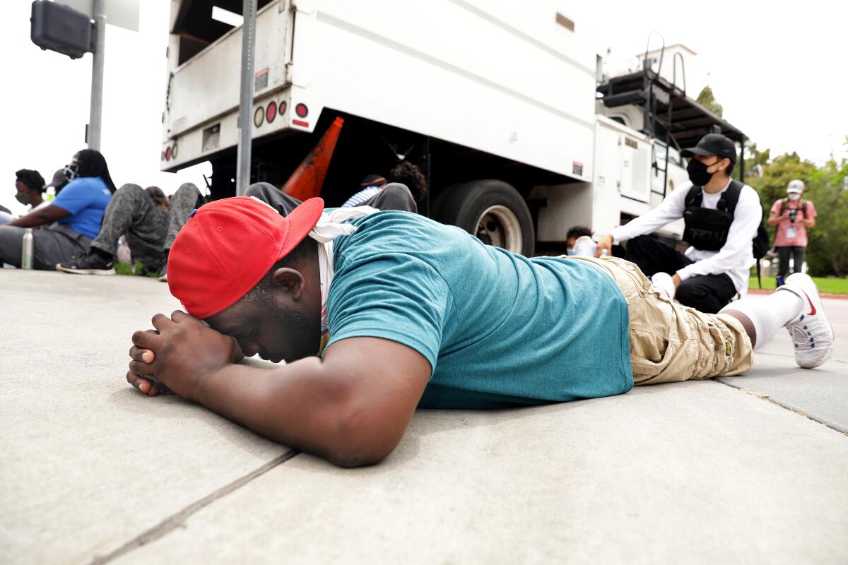 Michael O'Quinn, 45, of Compton, prays during a peaceful protest where demonstrators laid down for the amount of time that George Floyd was on the ground, outside the Cerritos Sheriff's Station in Cerritos on Monday.
