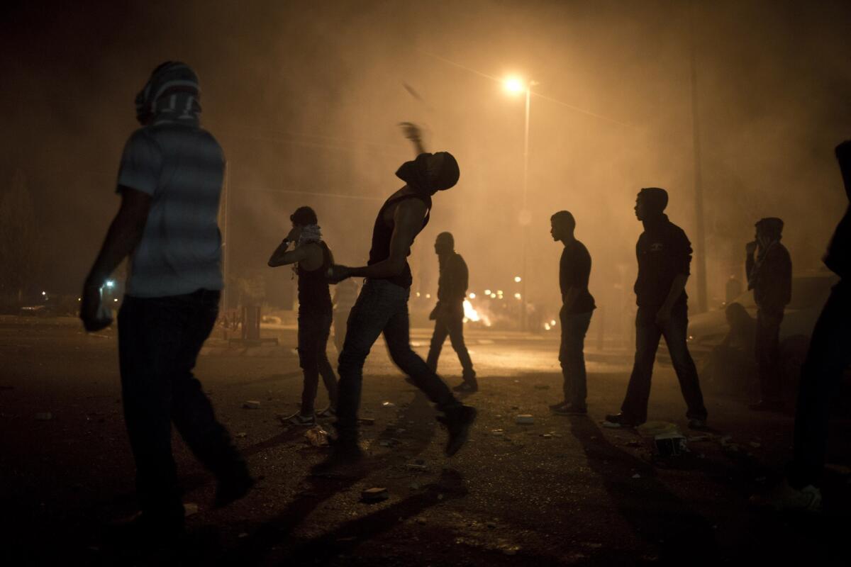 Israel Bedouins throw stones at police Saturday near Hura during a protest of the government's relocation plan.