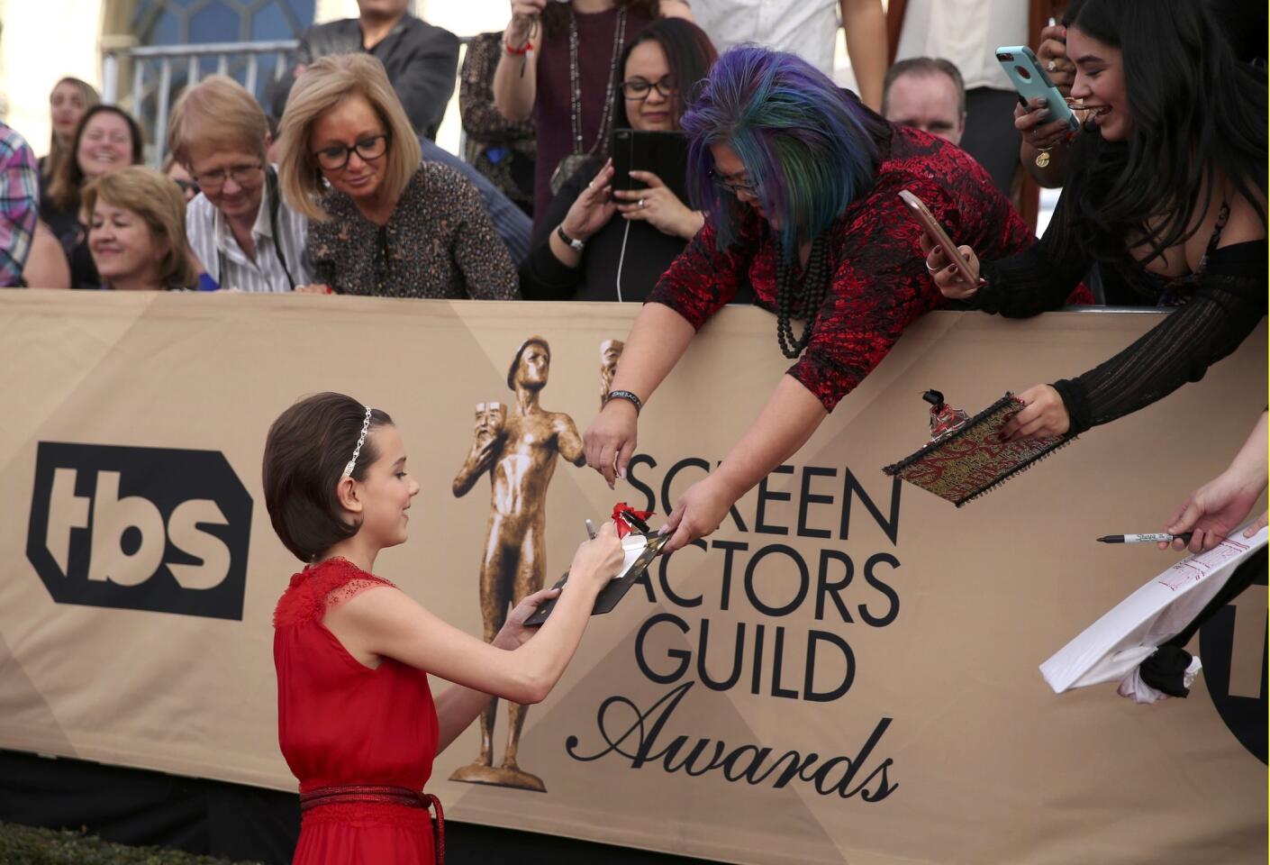 Actress Millie Bobby Brown signs autographs as she arrives at the 23rd Screen Actors Guild Awards in Los Angeles