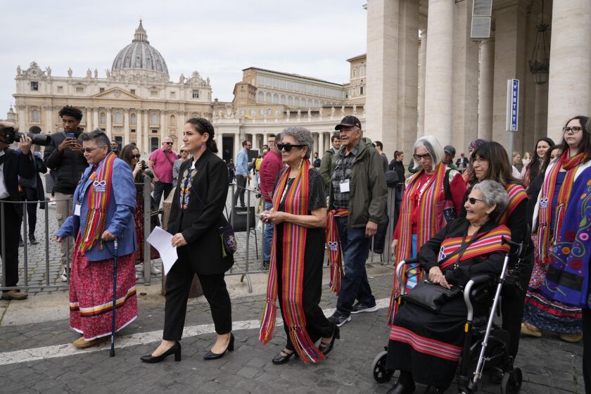 FILE - President of the Metis community, Cassidy Caron, second left, and other delegates arrive to speak to the media in St. Peter's Square after their meeting with Pope Francis at The Vatican, March 28, 2022. Pope Francis’ trip to Canada, which begins Sunday July 24, 2022, to apologize for the horrors of church-run Indigenous residential schools marks a radical rethink of the Catholic Church’s missionary legacy in the Americas, spurred on by the first American pope and the discovery of hundreds of unmarked graves at the school sites. (AP Photo/Gregorio Borgia, File)