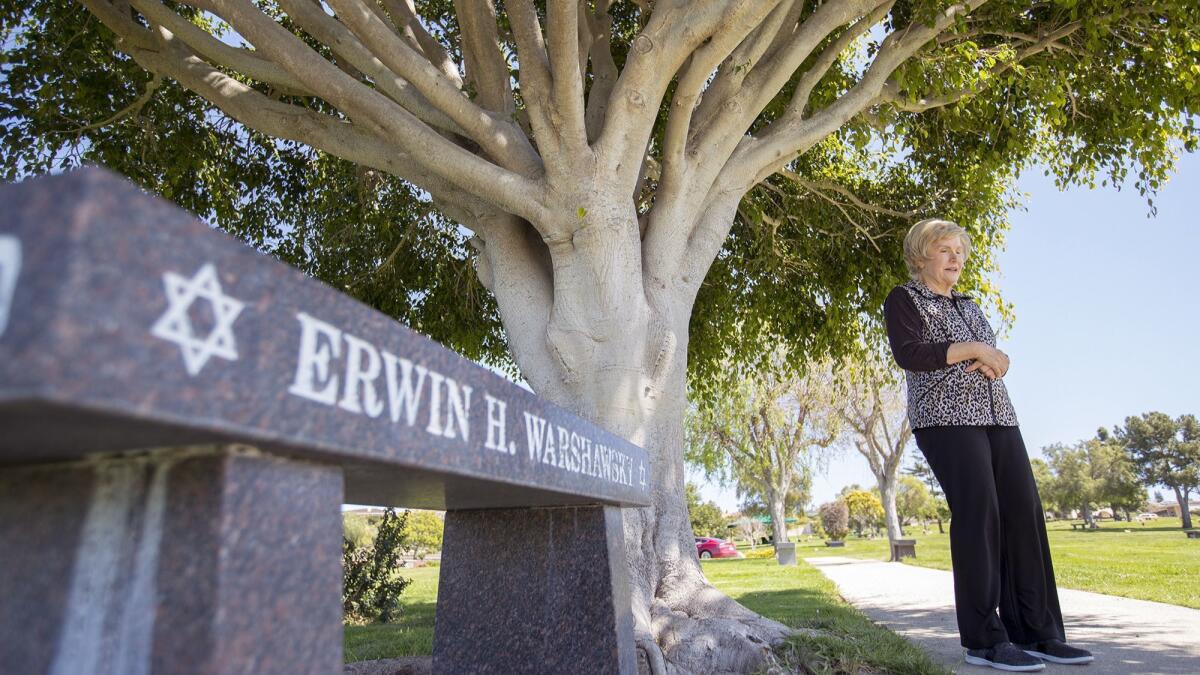 Latife Warshawsky stands under a ficus tree she planted 18 years ago near the grave of her husband, Erwin, at Pacific View Memorial Park & Mortuary in Corona del Mar. She sees the tree as a vessel for his spirit.