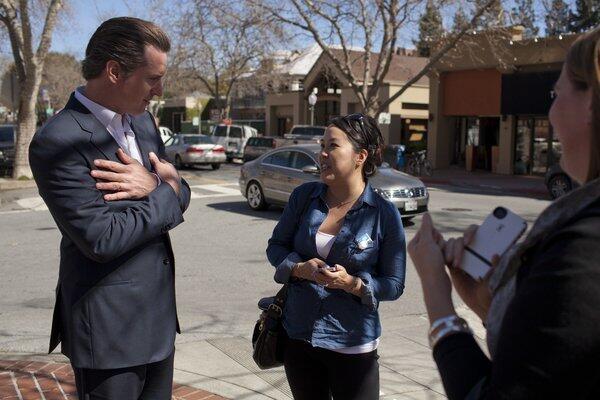 Lt. Gov. Gavin Newsom chats with Rowena Bacher on the street in Palo Alto in February.