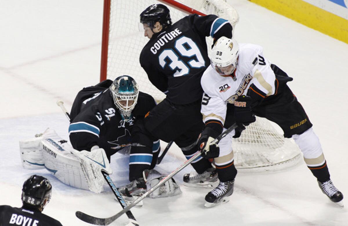 Ducks forward Jakob Silfverberg, left, battles with San Jose Sharks forward Logan Couture, center, and goalie Antti Niemi for a loose puck during the Ducks' 3-1 loss Sunday. The Ducks expect to see another physical game out of the Sharks on Tuesday.