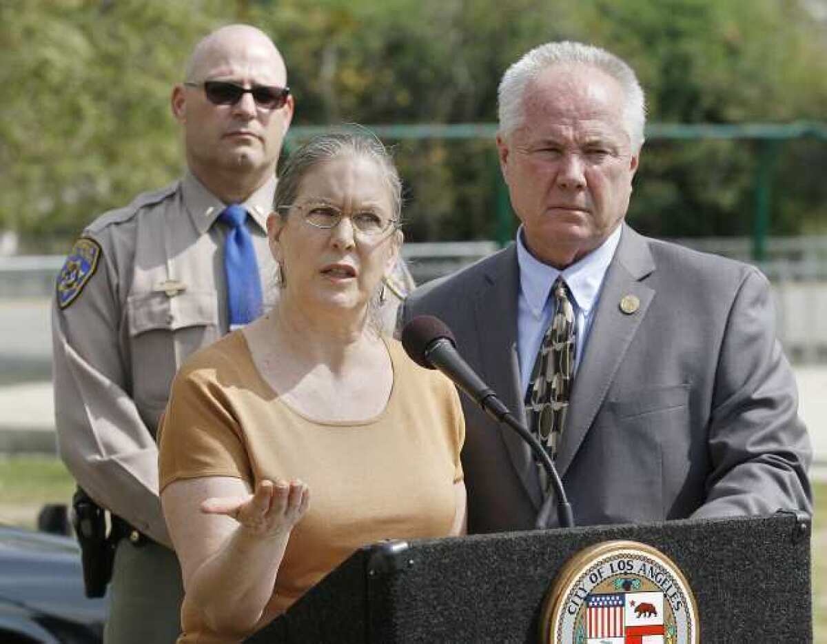 Michele Kevitt Kirkland, the mother of severely injured Damien Kevitt, with CHP Lt. David Moeller and L.A. Councilman Tom LaBonge behind her, speaks about her son at a press conference to announce a $25,000 reward in conjunction with a Zoo Drive cyclist hit-and-run at the Griffith Park Ferraro Soccer Fields in Los Angeles.