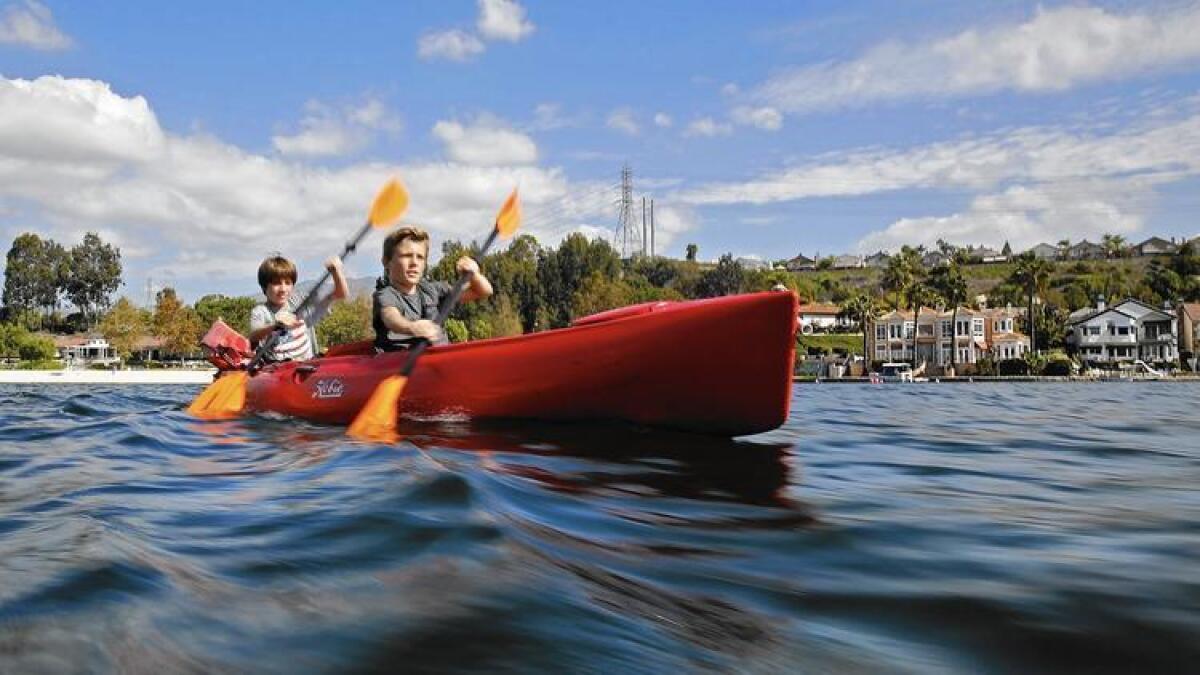 Keath Sahagun y su hermano Kaiden, ambos de 12 años de edad, reman en un kayak a través del Lago Mission Viejo. ()